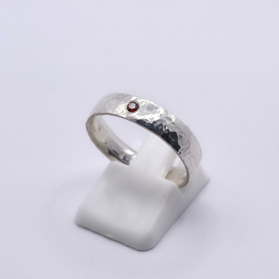 Seitenansicht eines 925 Silberringes mit rotem Zirkonia und Hammerschlagoptik 