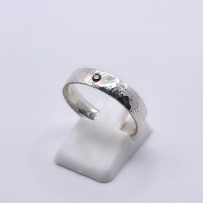 Seitenansicht eines 925 Silberringes mit rotem Zirkonia und Hammerschlagoptik 