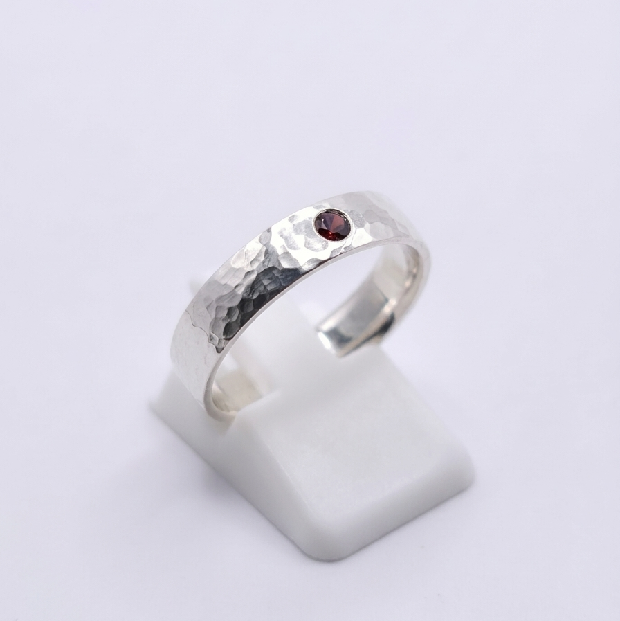 Seitenansicht eines 925 Silberringes mit rotem Zirkonia und Hammerschlagoptik 