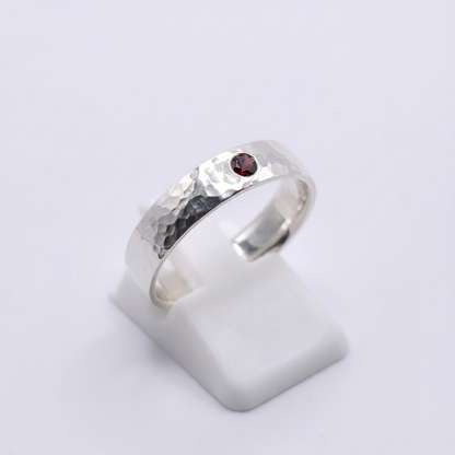 Seitenansicht eines 925 Silberringes mit rotem Zirkonia und Hammerschlagoptik 